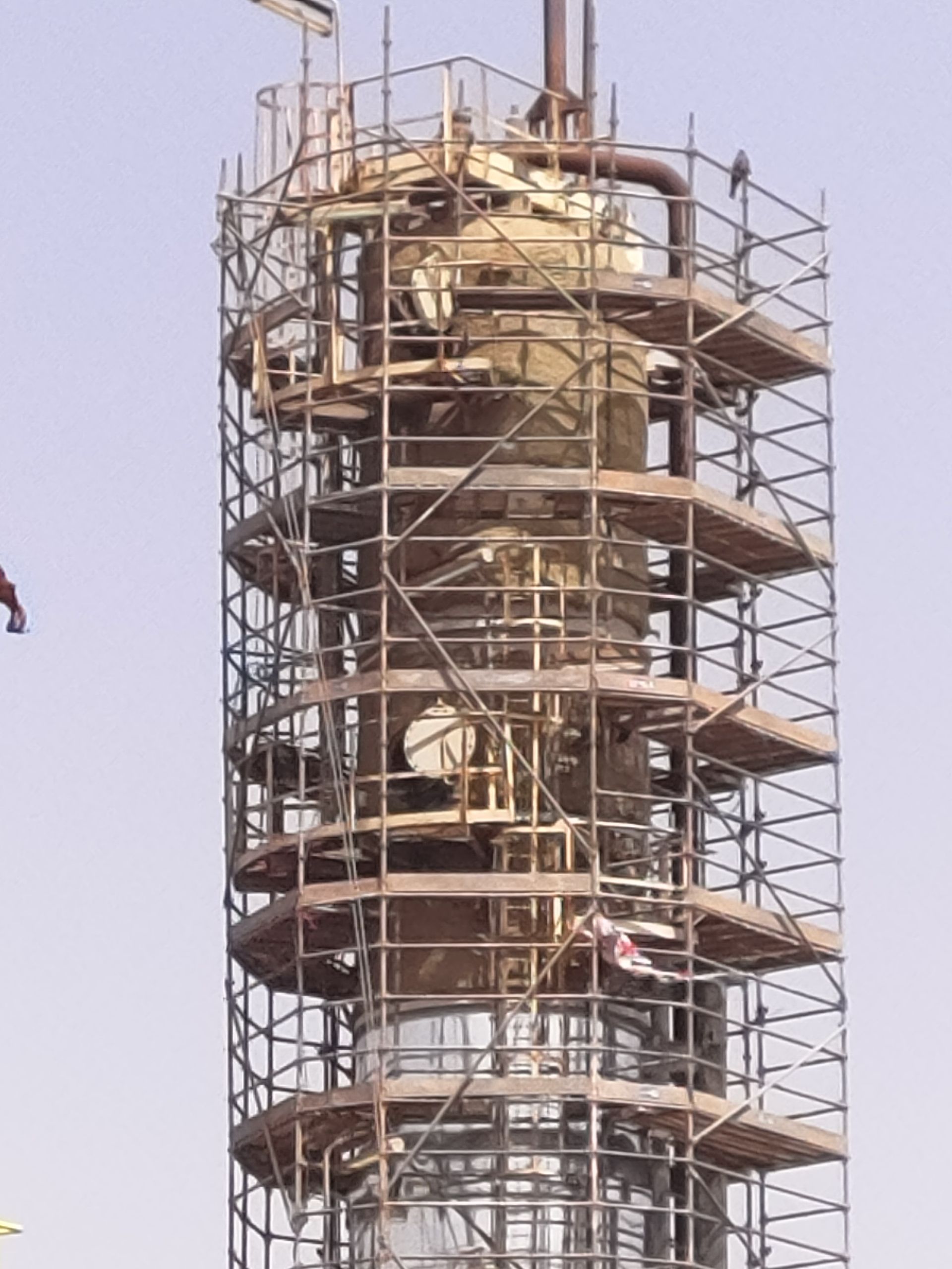 Haute structure cylindrique enveloppée d’échafaudages